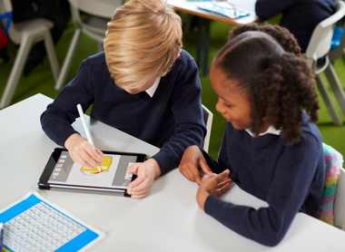 Elevated view of a girl and a boy using a tablet computer iStock-1092191870.jpg